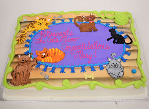 MaArthur's Bakery Custom Cake Sprayed Blue, with Mutiple Cats Laying on a Rug.