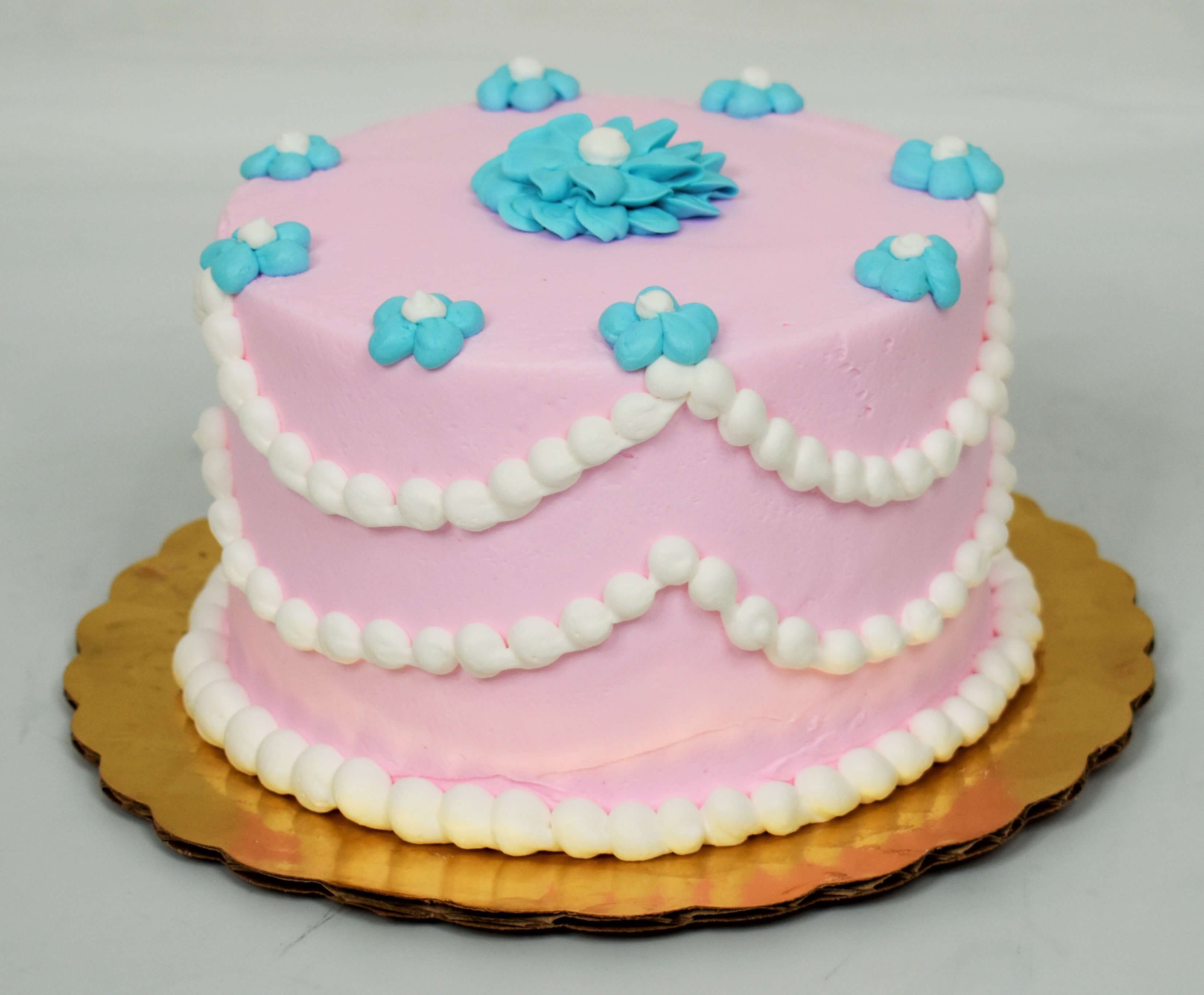 MaArthur's Bakery Custom Cake with Pink Background, White Beaded Draping, and Blue Flowers