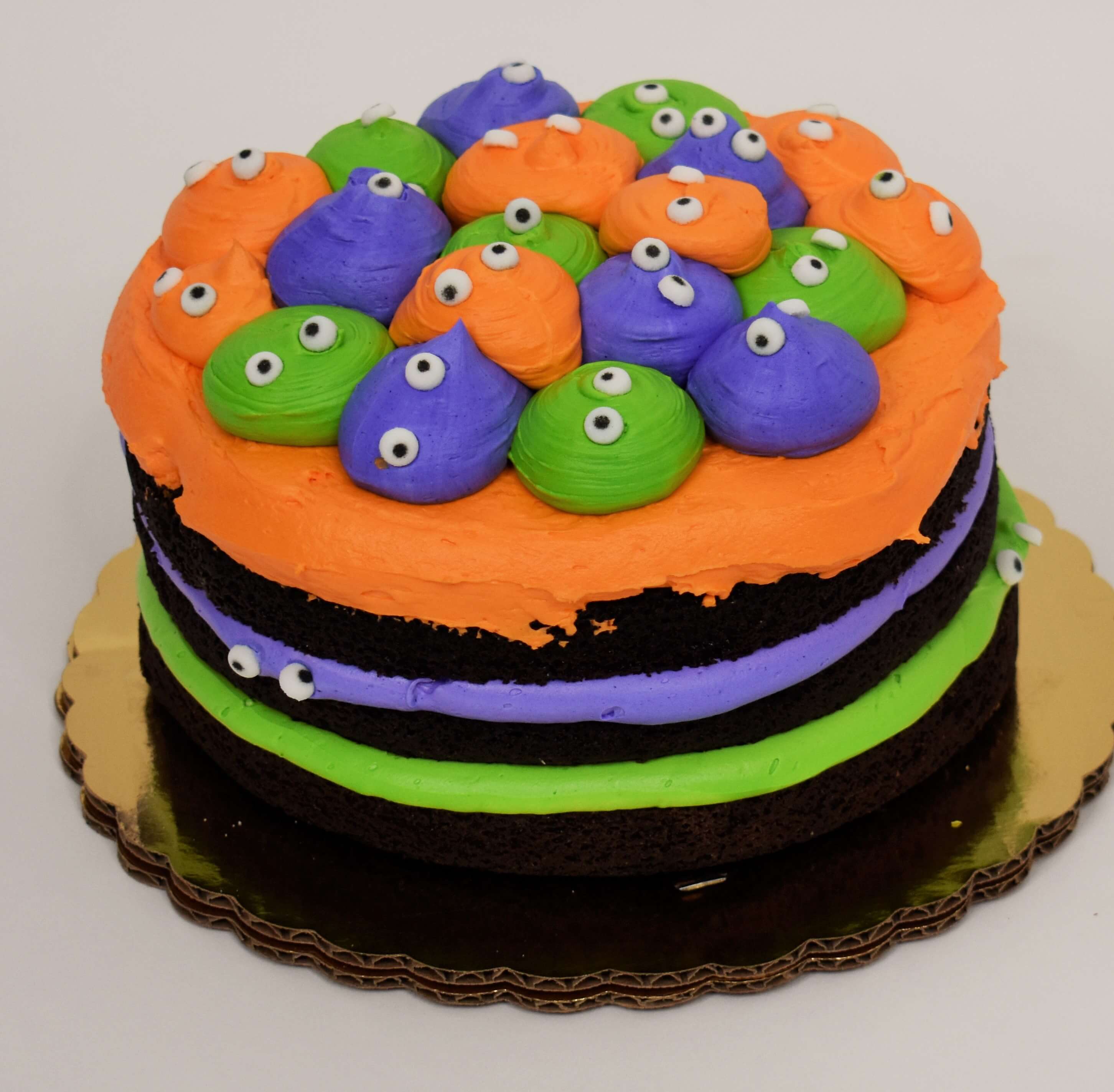 MaArthur's Bakery Custom Cake with Orange, Purple, and Green Heads with Eyes.