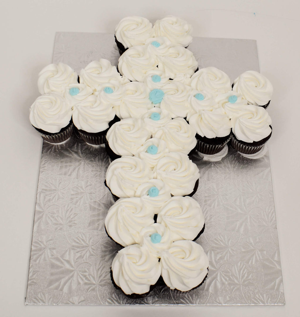 McArthur's Bakery Cupcake Cake In the shape of a cross with white and blue icing.